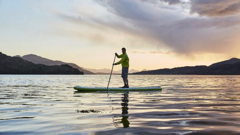 Paddle boarder on sup in cold weather in winter.